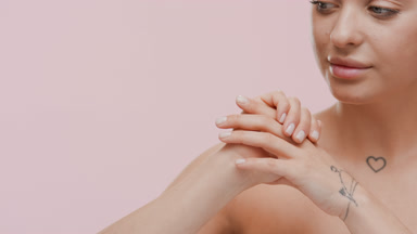 Young woman rubs hands, smells them and looks at camera smiling