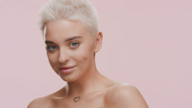 Caucasian woman with bare shoulders turns to the camera smiling