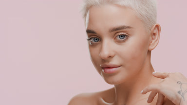 Attractive young Caucasian woman touches shoulders turning body