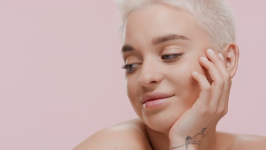 Woman turns head, put it on hand and looks at the camera smiling