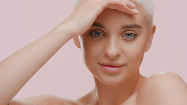 Cute Caucasian woman strokes forehead turning head and smiling