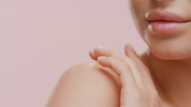 Blonde white-skinned female model strokes shoulder turning head