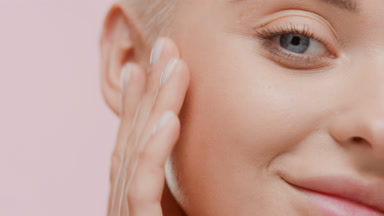 Beautiful Caucasian woman strokes her face looking at the camera