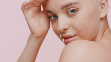 Gorgeous Caucasian woman strokes face moving head up and smiling
