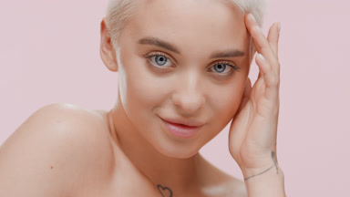 Pretty Caucasian woman strokes face turning head to the camera