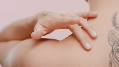 Good-looking slim white-skinned woman strokes neck and shoulder