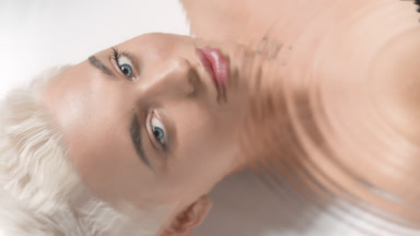 Caucasian woman turns head and opens eyes through rippling water