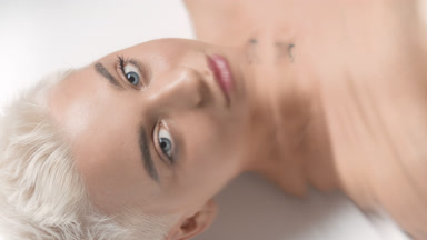 Pretty young slim woman turns head and opens eyes through water