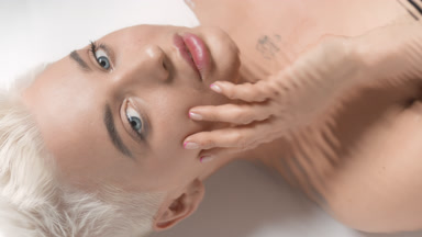 Underwater portrait of cute young Caucasian woman strokes face
