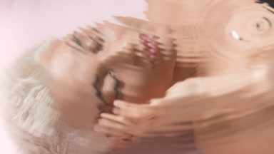 Pretty slim woman strokes face looking at camera through water