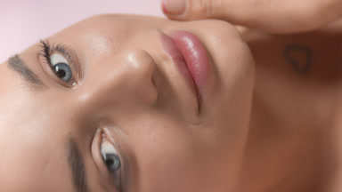 Cute Caucasian woman strokes lip smiling through rippling water