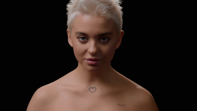 Woman moves head up, opens eyes and looks at the camera smiling
