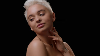 Pretty young Caucasian woman strokes face and neck turning head