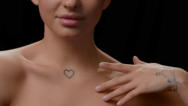 Good-looking white-skinned woman strokes clavicles turning head