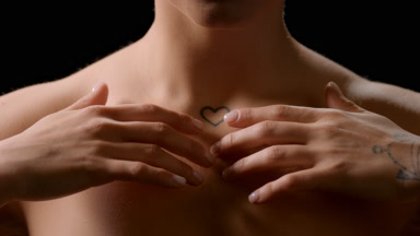 Good-looking slim white-skinned woman strokes clavicles smiling
