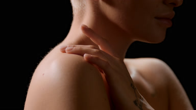Good-looking white-skinned woman strokes shoulder turning head