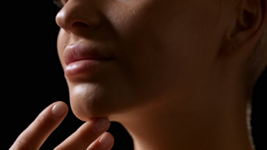 Attractive young slim blonde Caucasian woman strokes her jawline