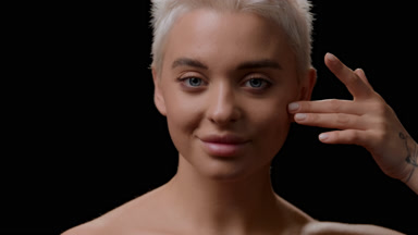 Slim woman strokes cheek turning head to the camera and smiling