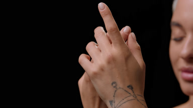 Caucasian woman strokes hand and looks at the camera smiling