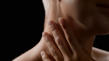 Good-looking slim young blonde white-skinned woman strokes neck