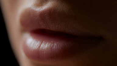 Macro shot of lips of white-skinned female model opening