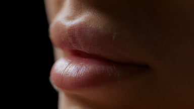 Macro shot of lips of white-skinned female model moving