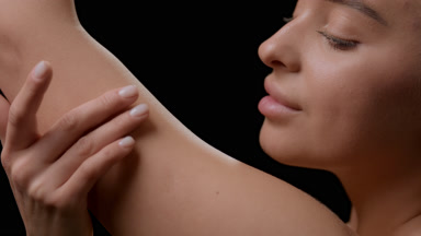 Attractive young slim blonde Caucasian woman strokes her arm