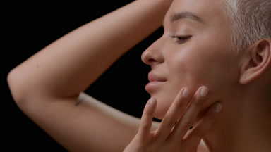 Gorgeous young Caucasian woman strokes jawline moving head up