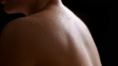 Close-up of white-skinned light-haired woman moves wet shoulders