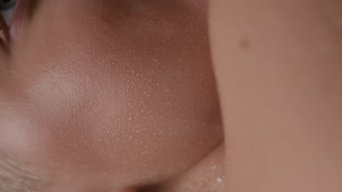 Macro shot of moving wet elastic clean cheek of female model