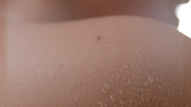 Macro shot of wet shoulder and moving wet head of female model
