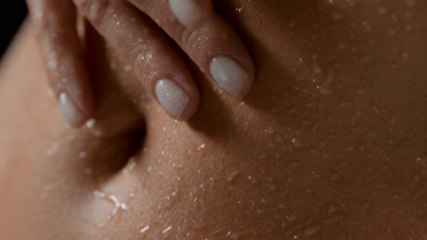 Macro of slim female model strokes wet good-looking flat belly