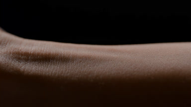 Macro shot of woman's white flawless smooth pure arm skin moving