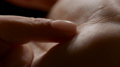 Macro shot of woman's finger touches her soft clean palm