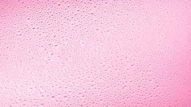 Medium size water drops blown off the glass surface on pink bg