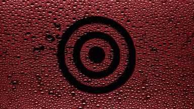 Red target sign blown off the wet glass on black background