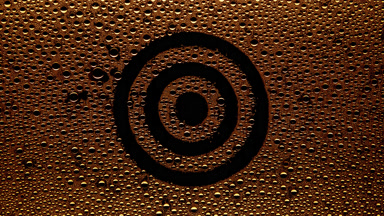 Orange target sign blown off the wet glass on black background