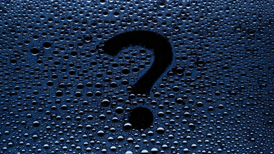 Blue question mark blown off the wet glass on black background