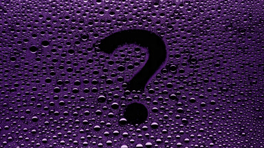 Purple question mark blown off the wet glass on black background