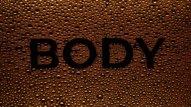 Orange body word blown off the wet glass on black background