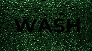 Green wash writing blown off the wet glass on black background