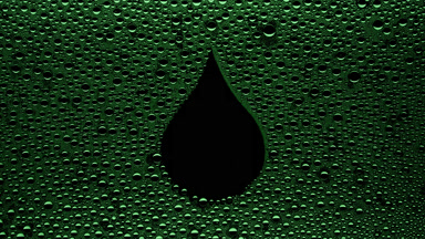 Green drop shape print blown off the wet glass on black bg