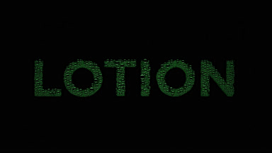 Green lotion text blown off the wet glass on black background