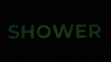 Green shower word blown off the wet glass on black background
