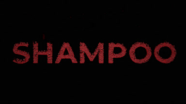 Red shampoo text blown off the wet glass on black background