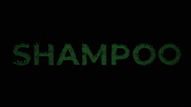 Green shampoo text blown off the wet glass on black background