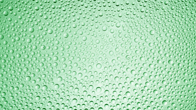 Drops from the wet glass being blown off on purple background