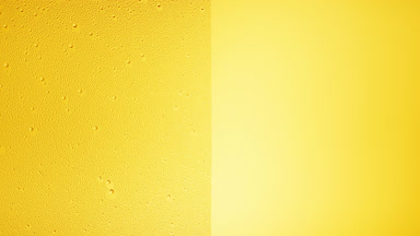 Drops are being blown off the half of the wet glass on a yellow bg
