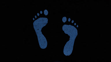 Inverted blue footprints blown off the wet glass on black bg