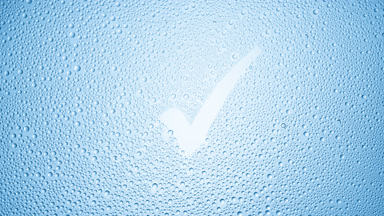 Checkmark blown off the wet glass on blue background